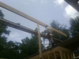 Carpenter setting a ridge beam over a new addition frame — Ice Dam Removal by Roofing Brothers in Hampshire