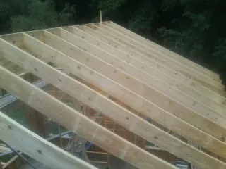 New roof rafters set over an addition before sheathing in Hampshire