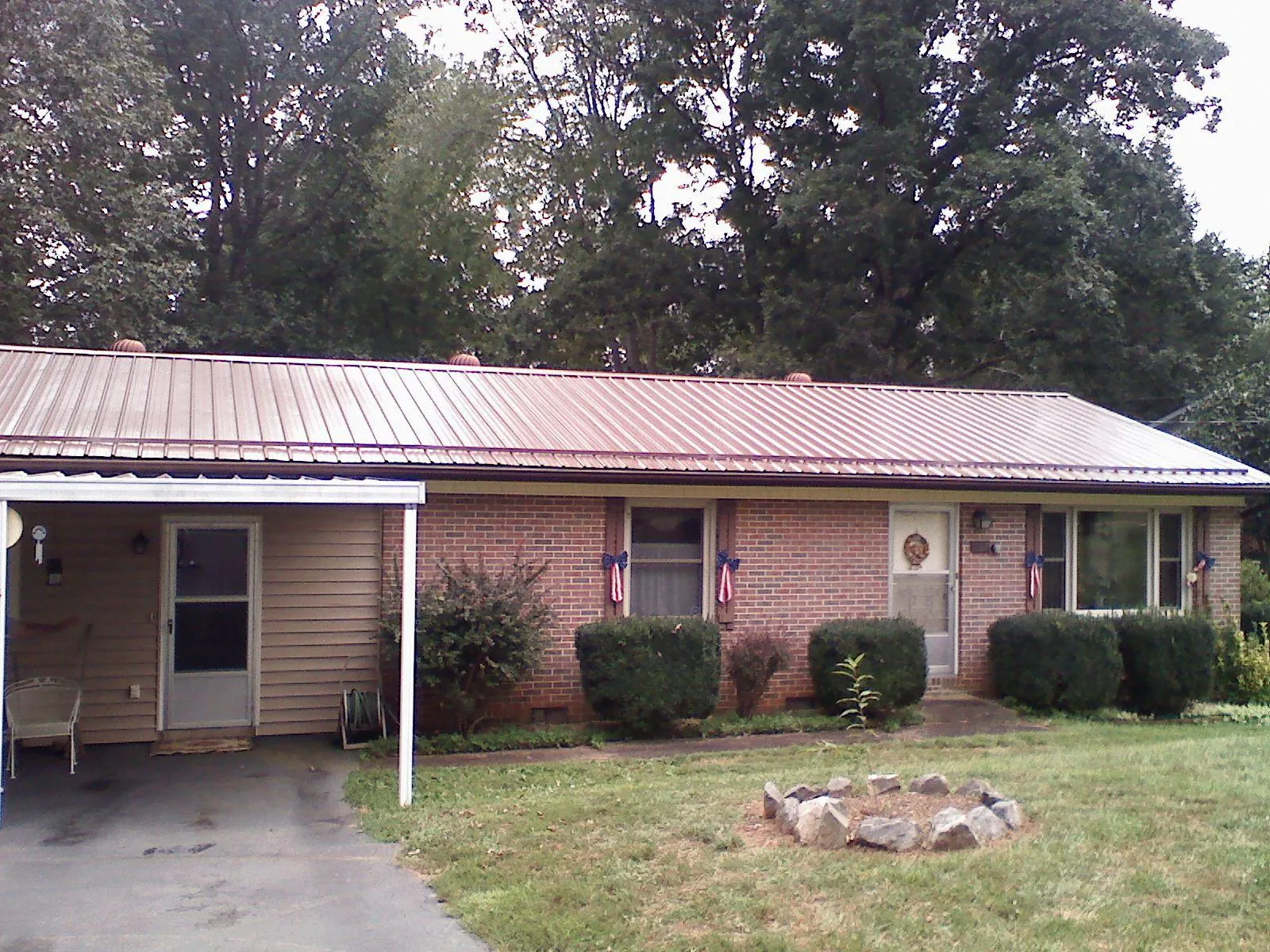Bronze metal roof and carport on a brick ranch home — Roof Repair work by our crew in Hampshire